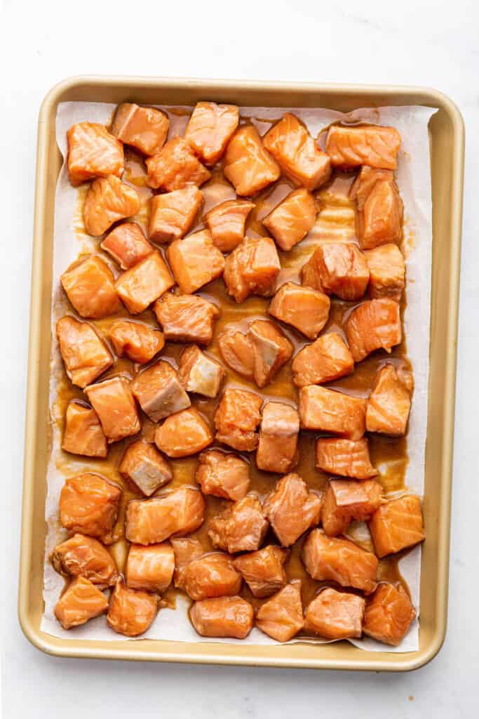 Overhead view of raw salmon on baking sheet