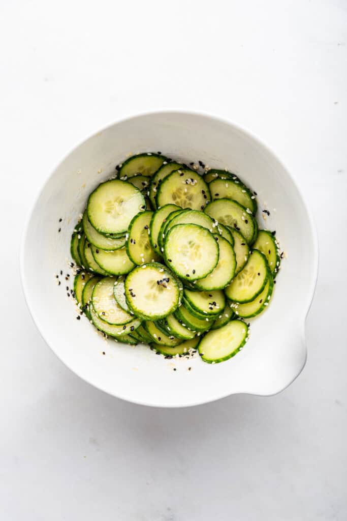 Overhead view of cucumber salad in mixing bowl