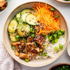 Overhead view of salmon bowl with cucumber, rice, and carrots