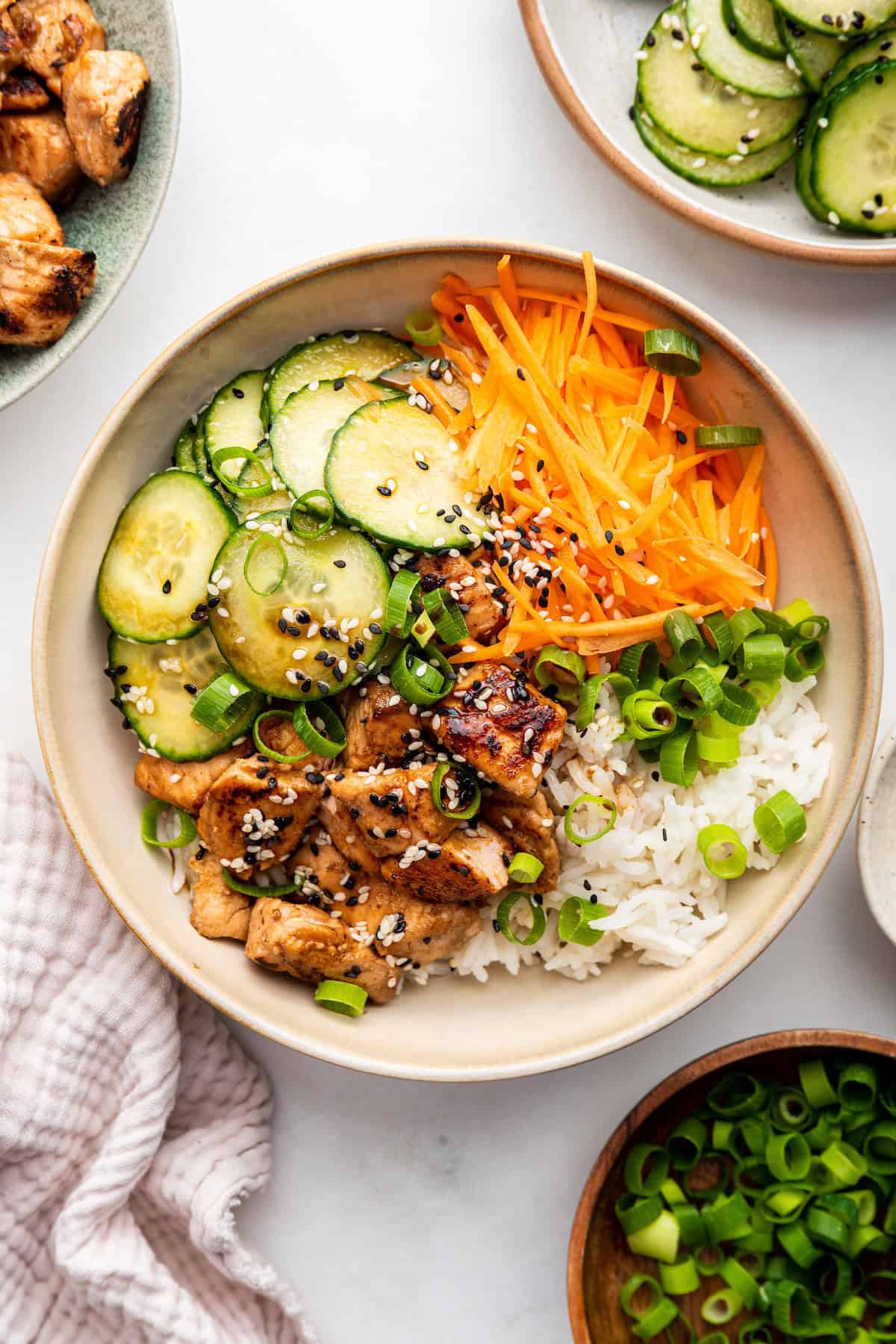 Overhead view of salmon bowl with cucumber, rice, and carrots