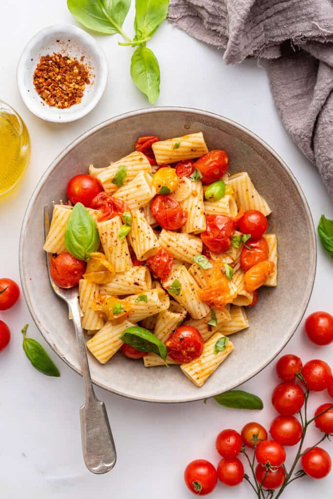 Overhead view of cherry tomato pasta in bowl with fork