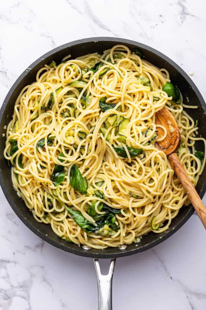 Stirring spaghetti alla Nerano to incorporate cheese