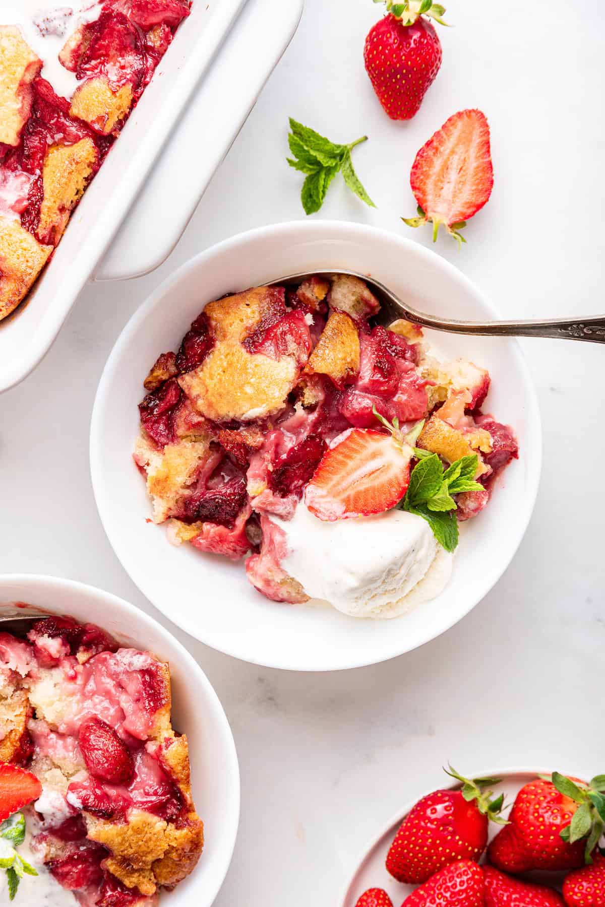 Bowls of strawberry cobbler topped with ice cream