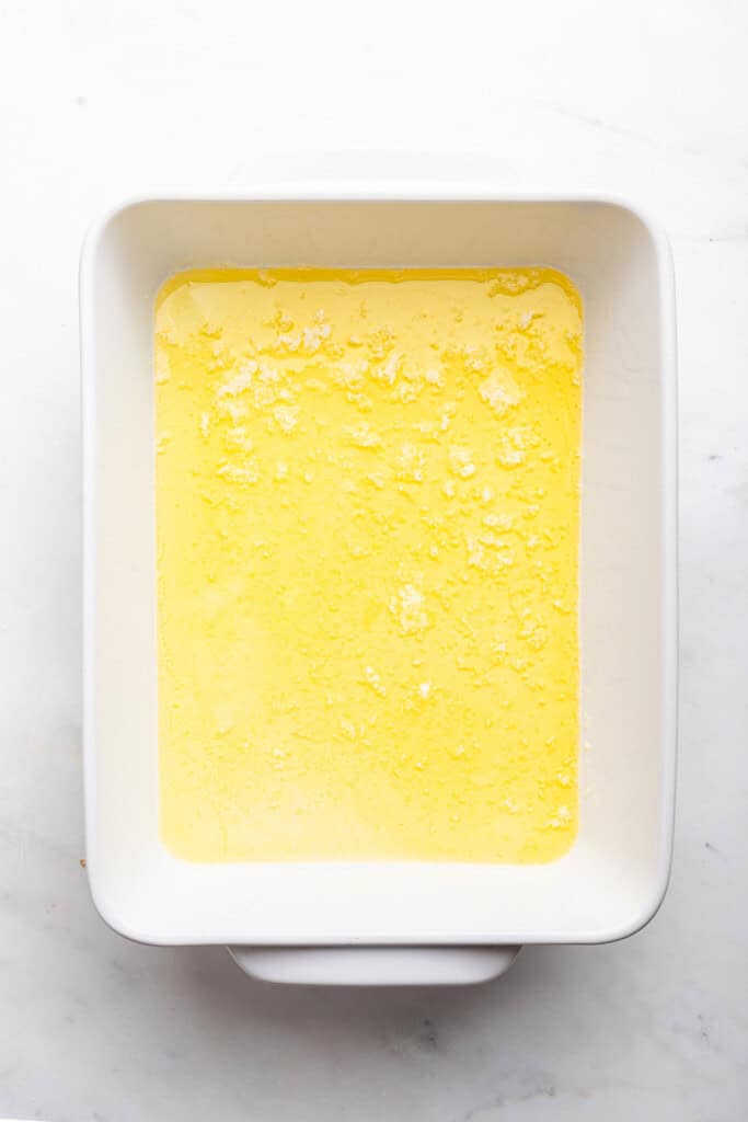 Overhead view of melted butter in baking dish
