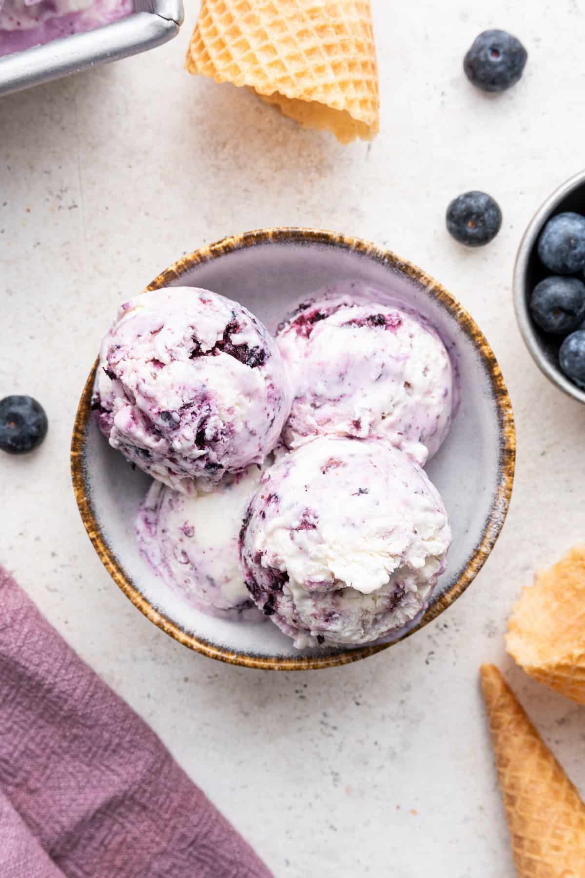 Overhead view of 4 scoops of berry cottage cheese ice cream in bowl