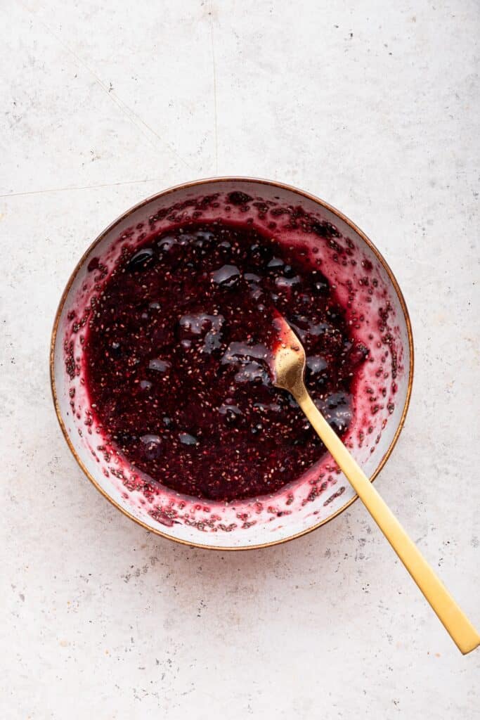 Overhead view of berries and chia seeds in bowl with spoon