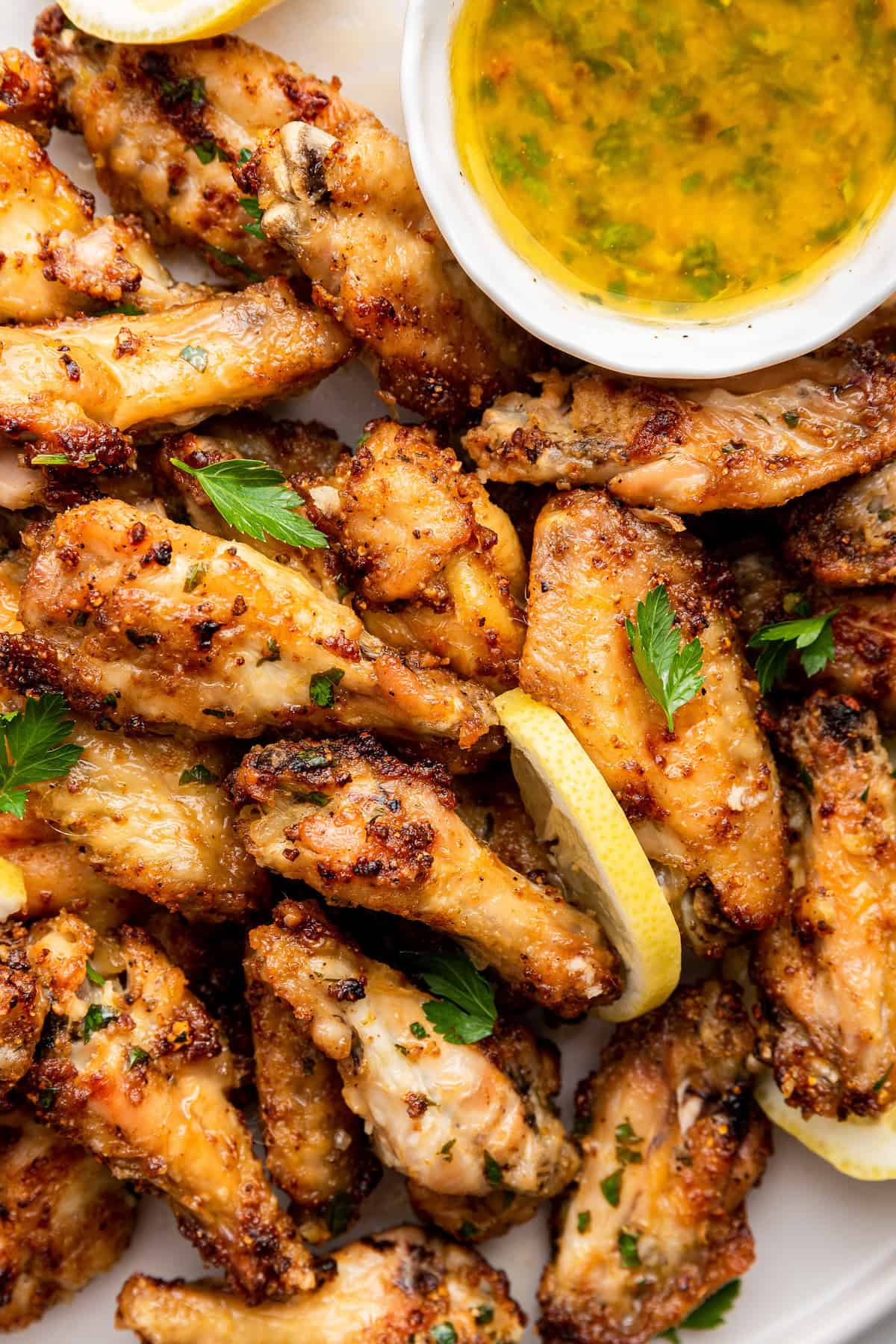 Overhead view of lemon pepper chicken wings with bowl of sauce