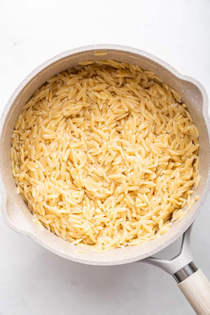 Overhead view of cooked orzo in pan