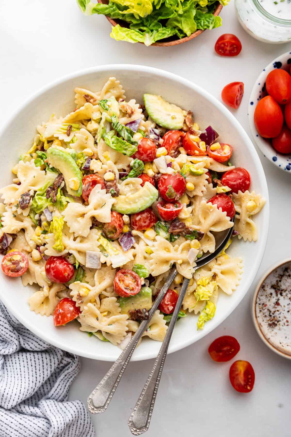 Overhead view of BLT pasta salad on plate with spoons