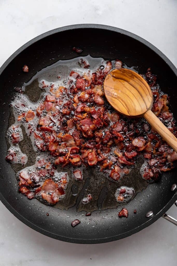 Overhead view of bacon cooking in skillet