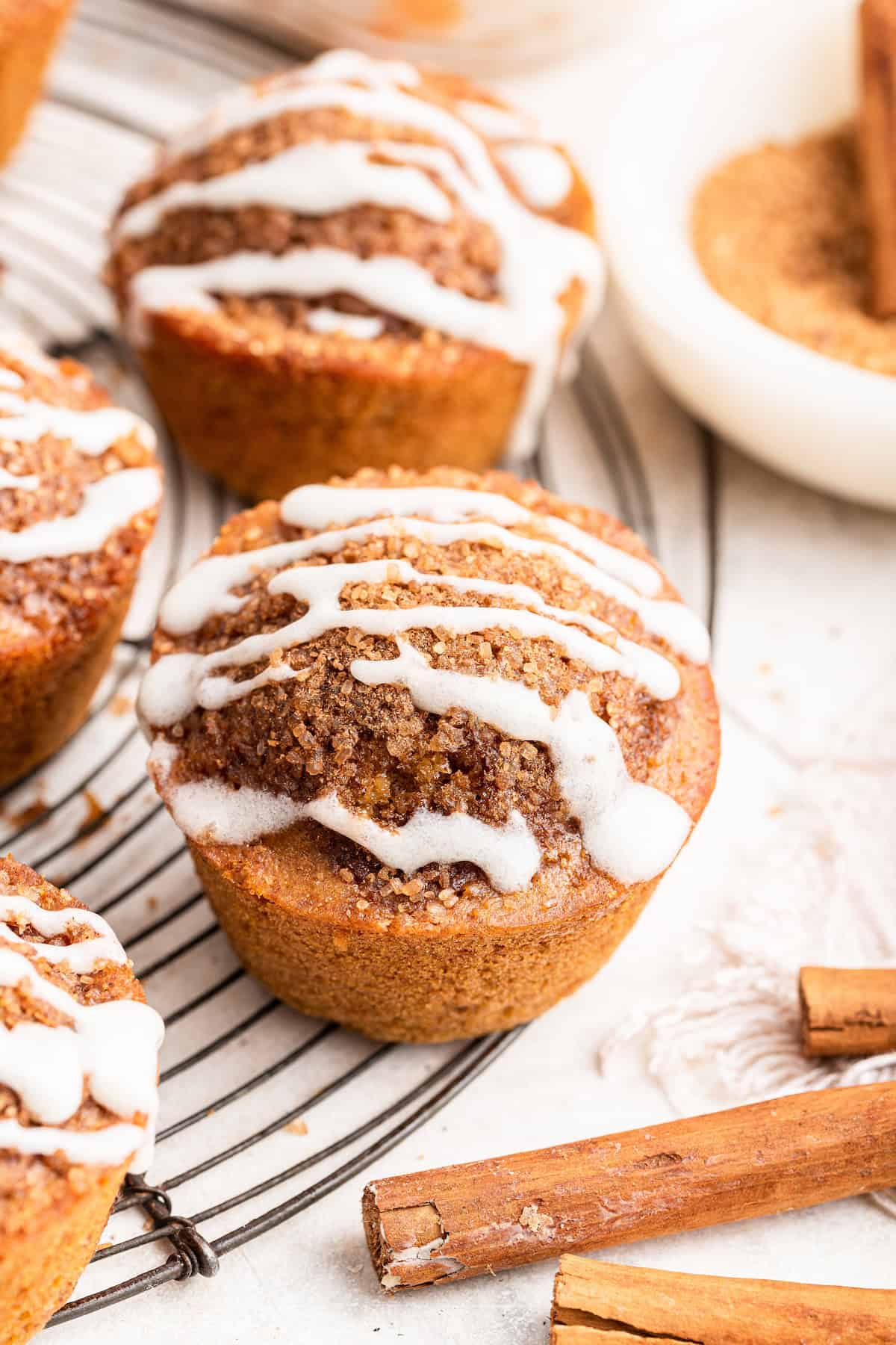 Cinnamon muffins with glaze on wire rack