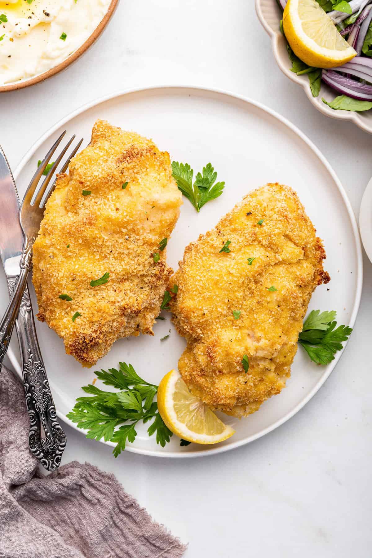 Overhead view of two garlic Parmesan chicken on plate