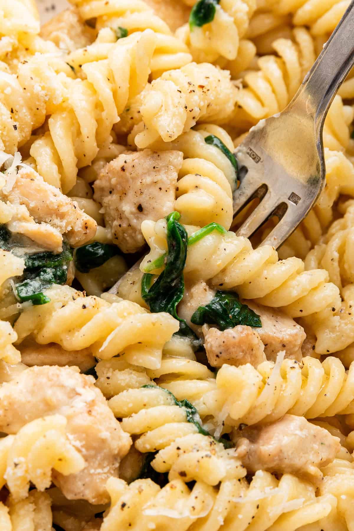 Fork digging into garlic Parmesan chicken pasta