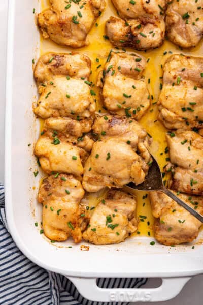 Baking dish with baked boneless chicken thighs