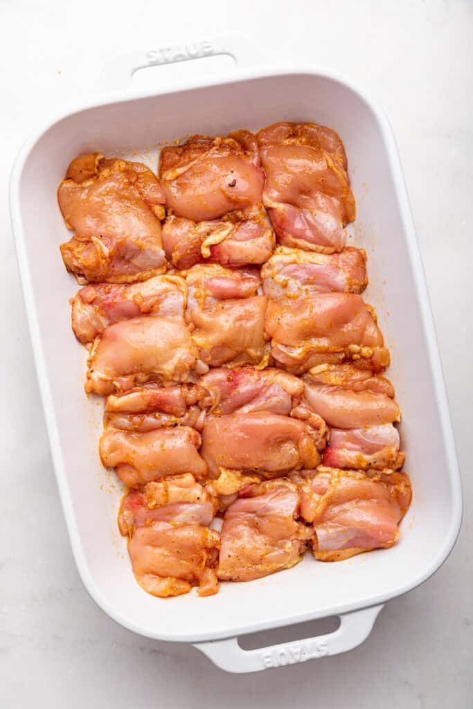 Overhead view of unbaked chicken thighs in baking dish