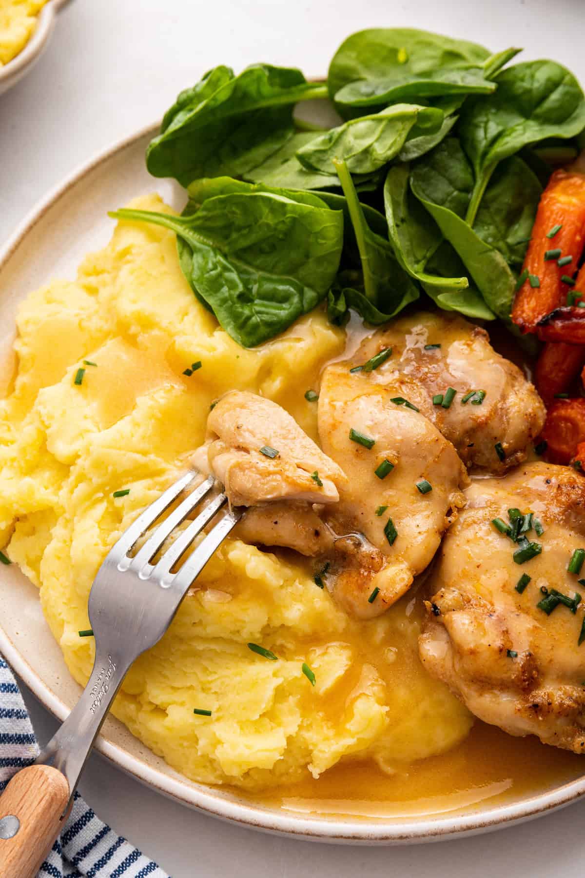 Plate with baked boneless chicken thighs, gravy, and mashed potatoes