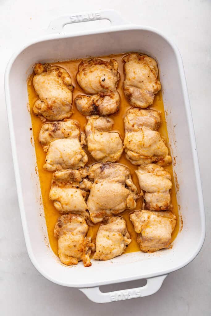 Overhead view of baked boneless chicken thighs in pan