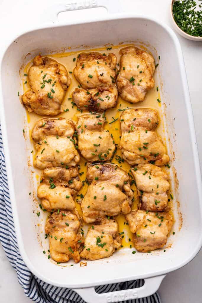 Overhead view of baked boneless chicken thighs in baking dish