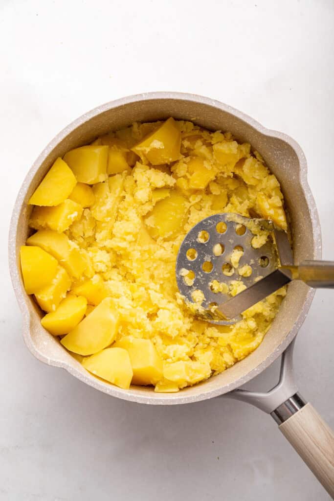 Mashing potatoes in pan