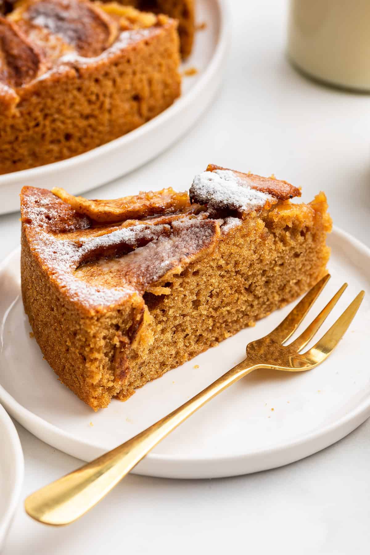 Slice of German apple cake on plate with fork