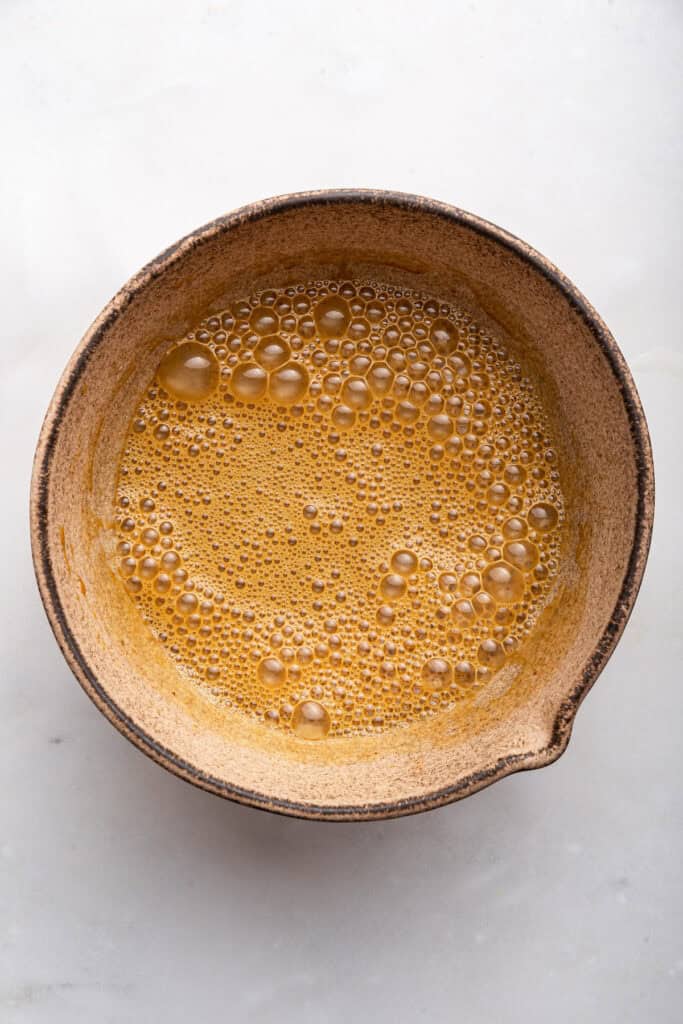 Wet ingredients for apple cake in mixing bowl