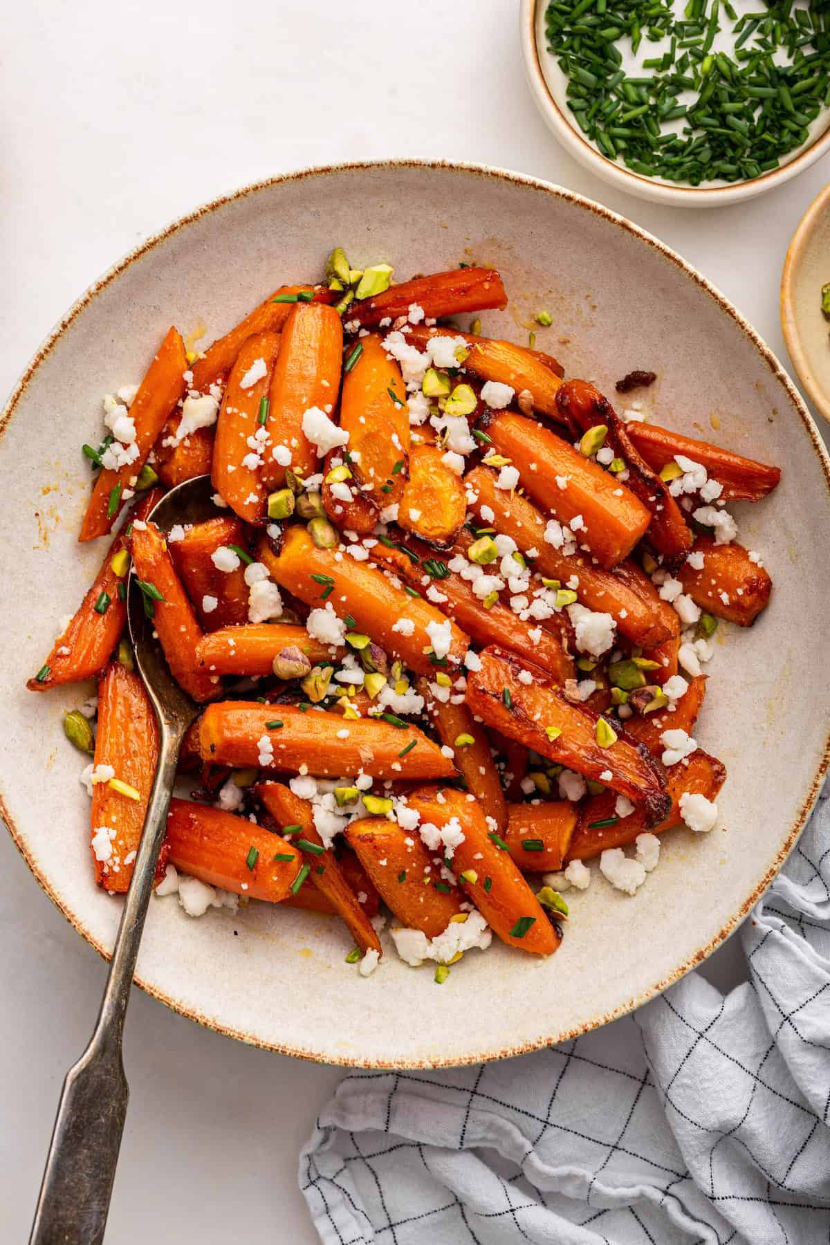 Overhead view of honey roasted carrots in dish with spoon