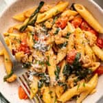 Bowl of sausage pasta with spinach and cherry tomatoes