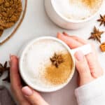 Hands holding mug of homemade chai latte