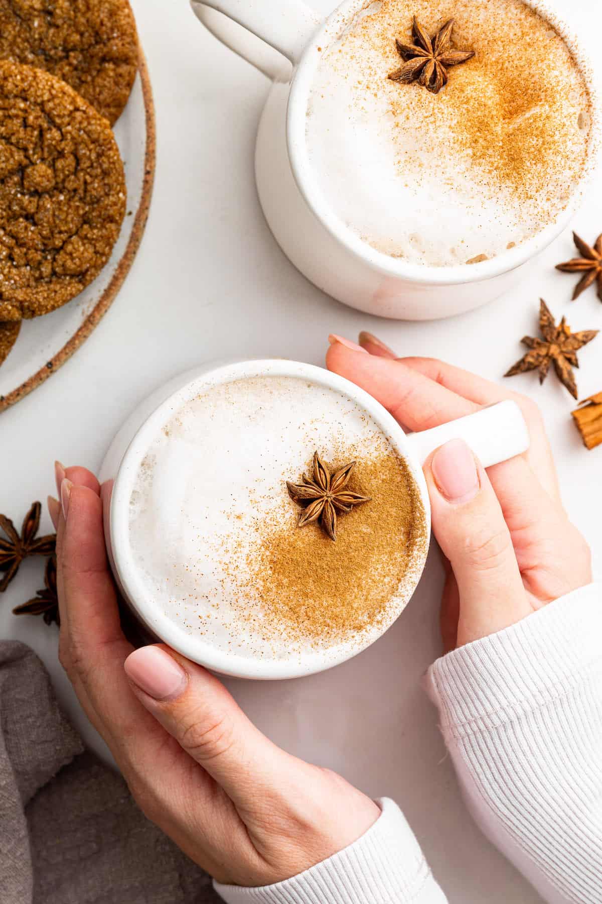 Hands holding mug of homemade chai latte