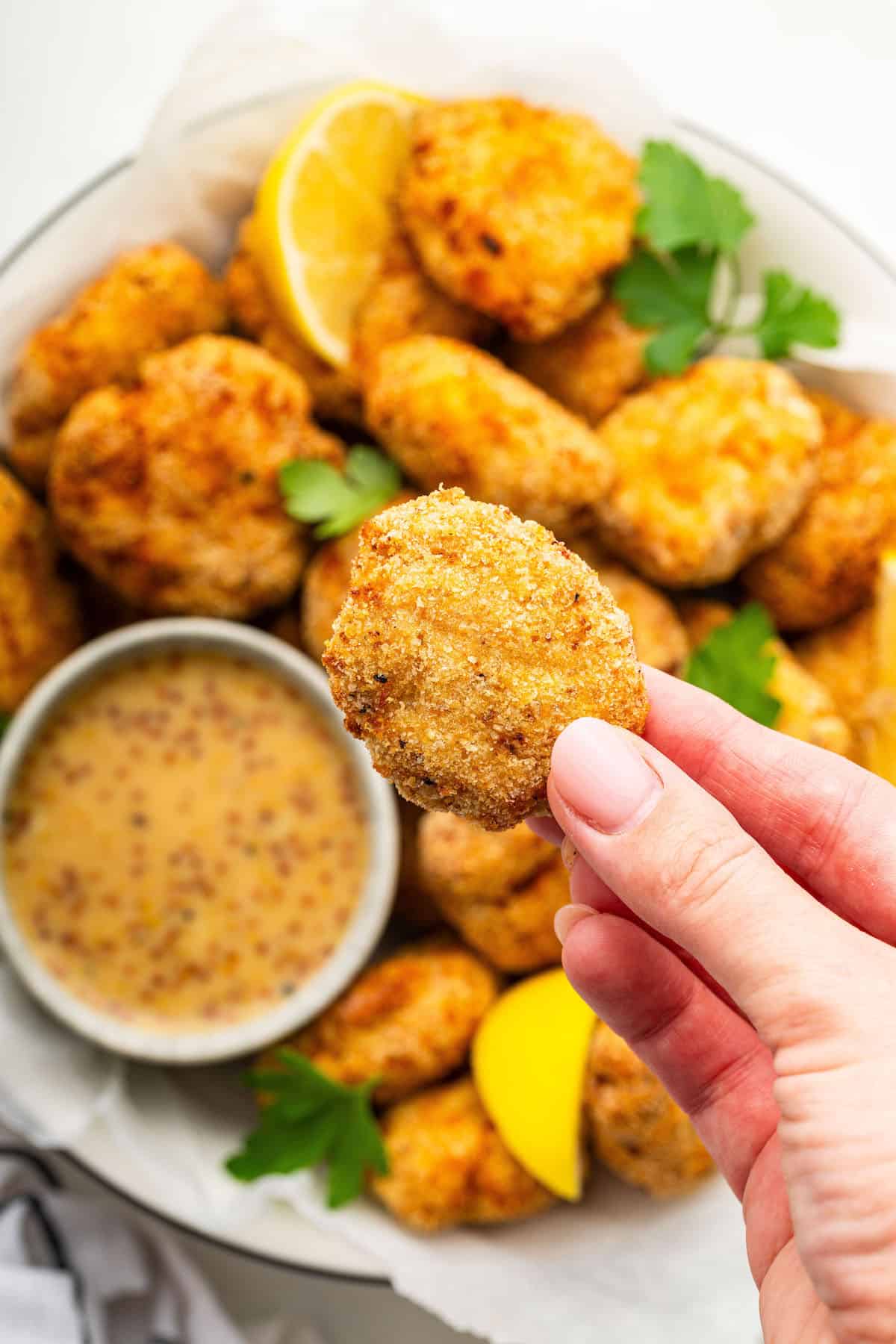 Hand holding air fryer chicken nugget