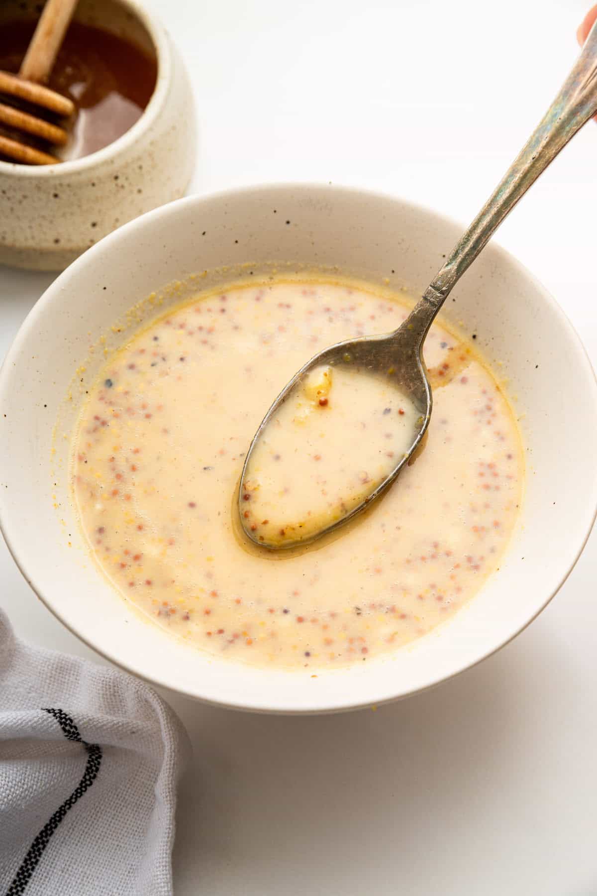 Spoonful of honey mustard dipping sauce in bowl