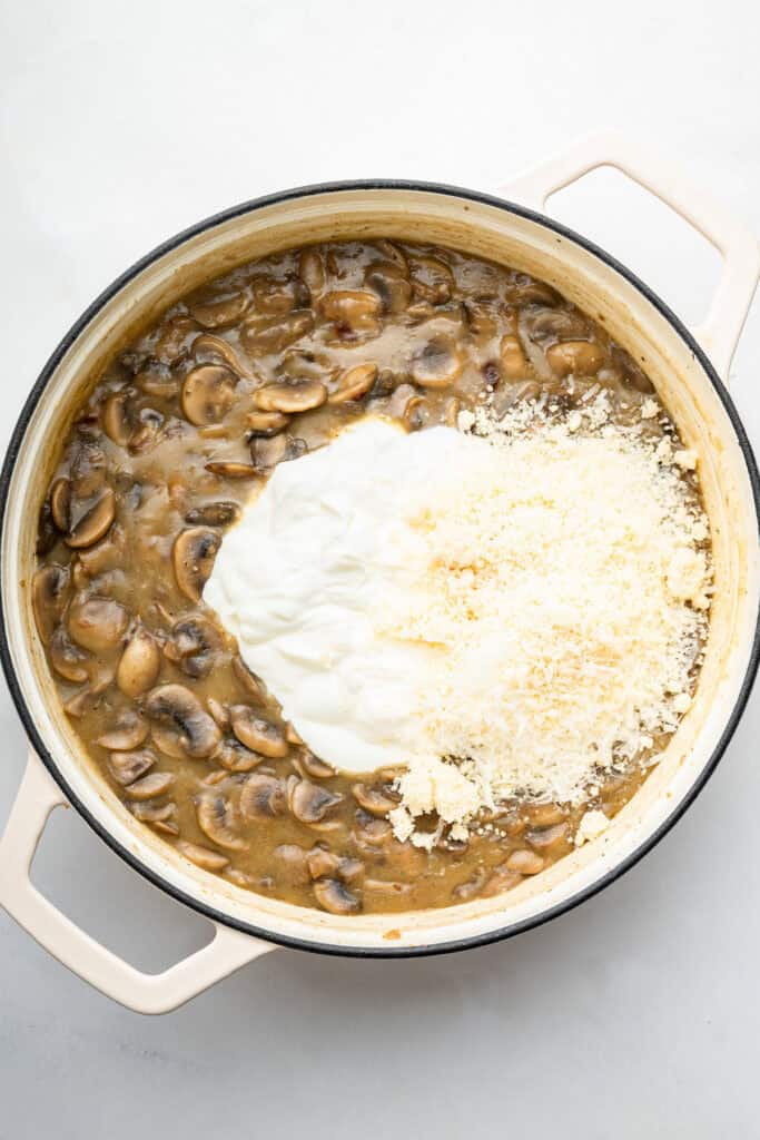 Yogurt and Parmesan added to mushroom and broth mixture in pan