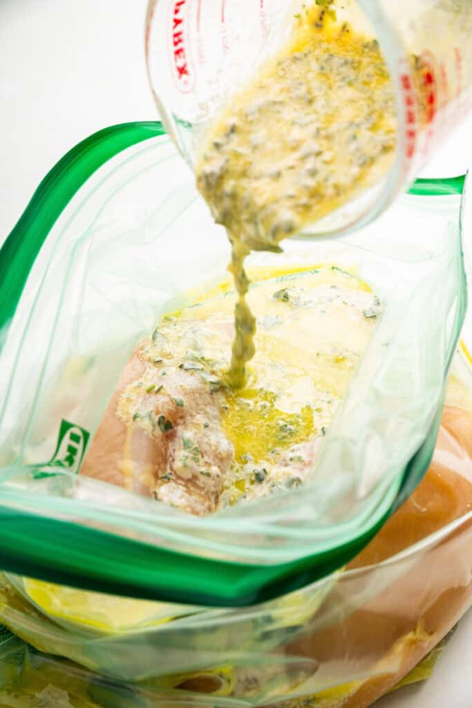 Pouring marinade into a ziplock bag.