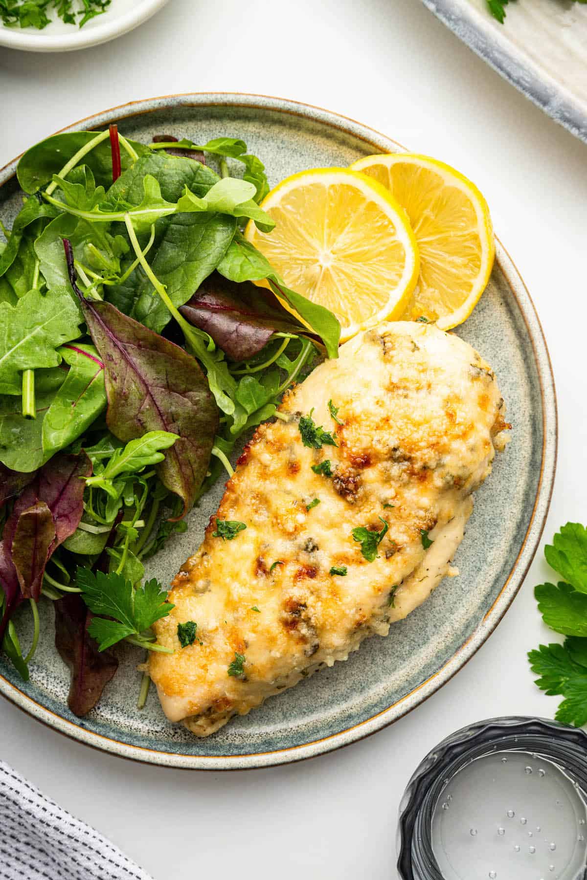 Italian Dressing Chicken on a plate with lemon and salad.