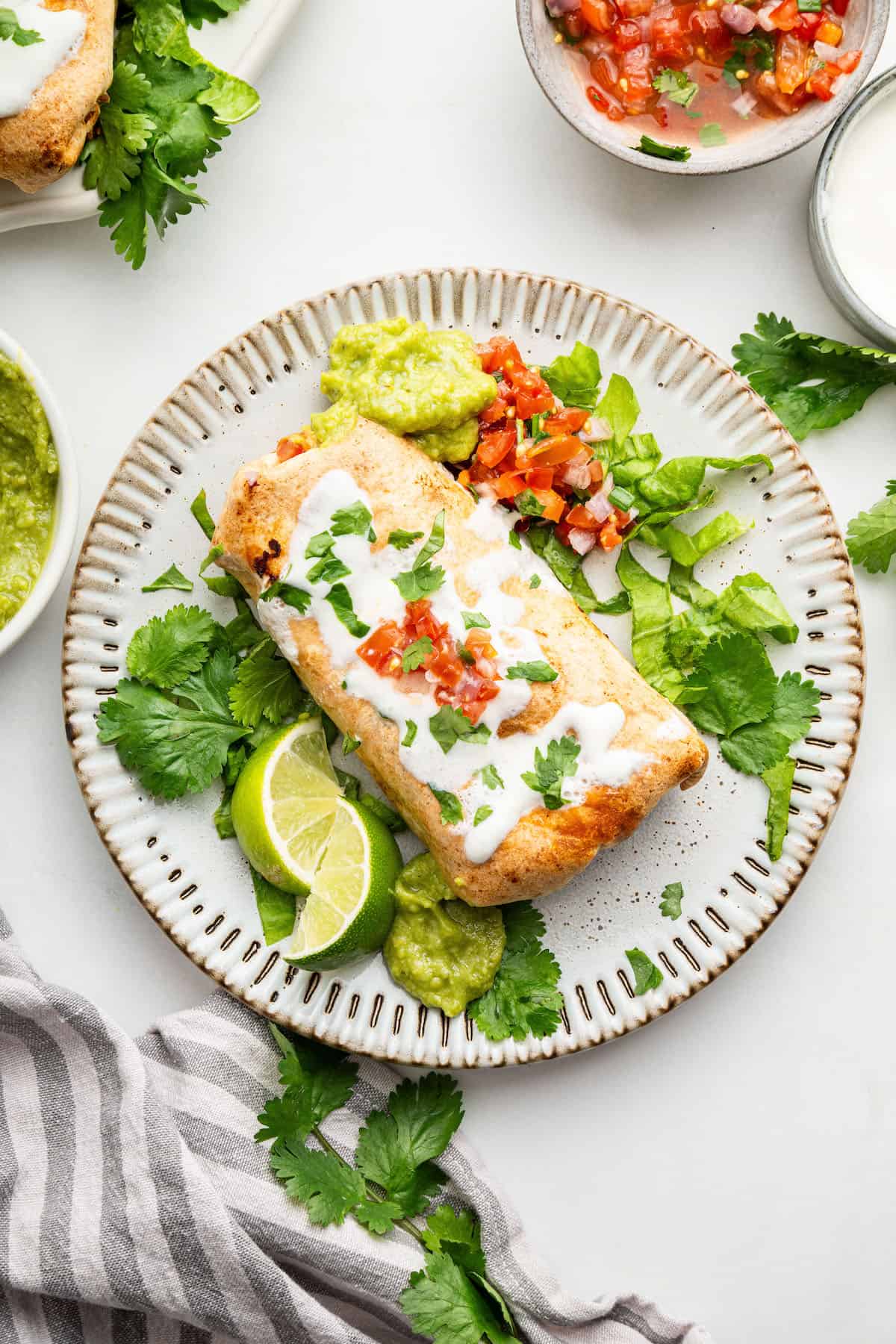 Overhead view of air fryer chimichanga on plate with toppings