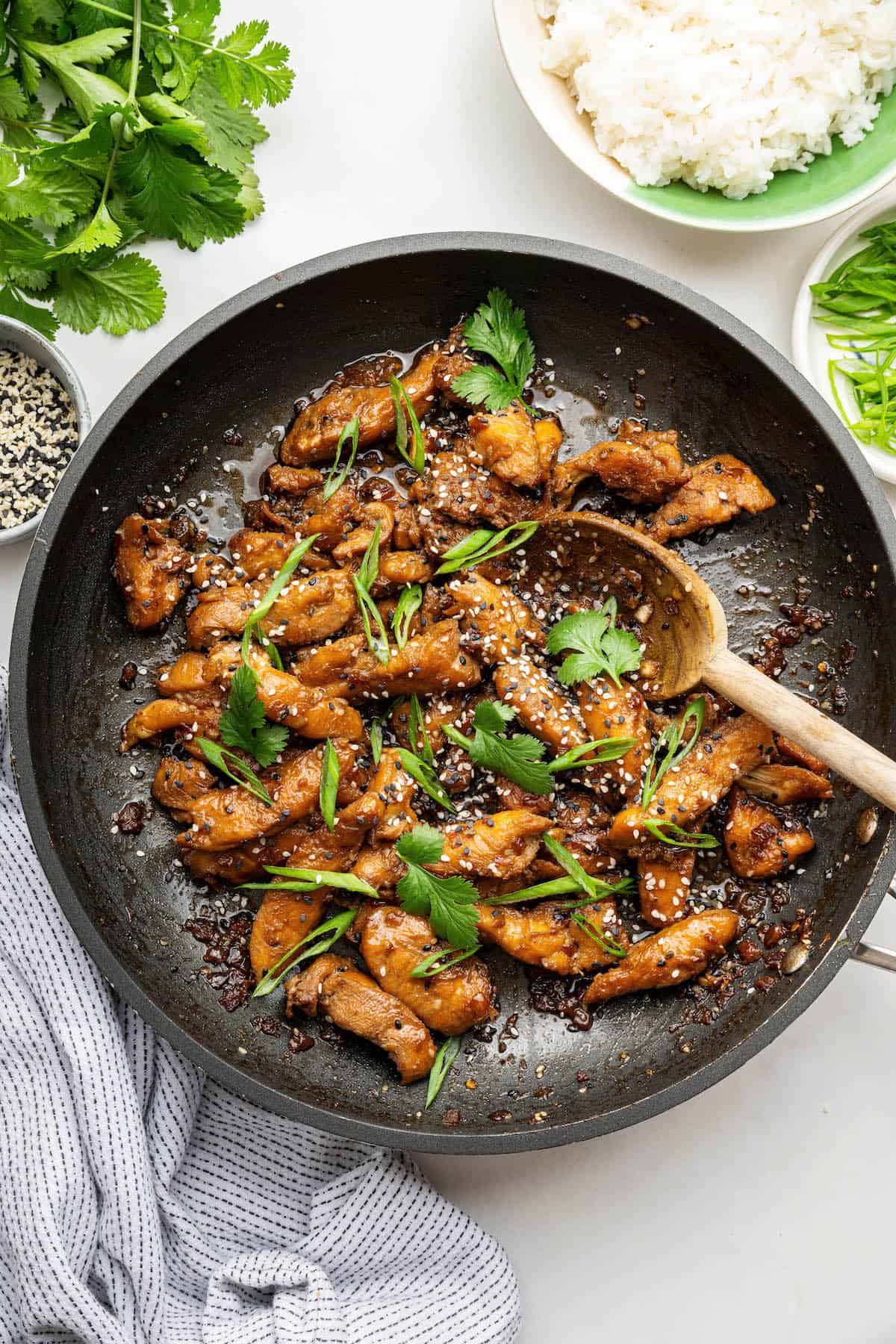 Bulgogi chicken in skillet with wooden spoon