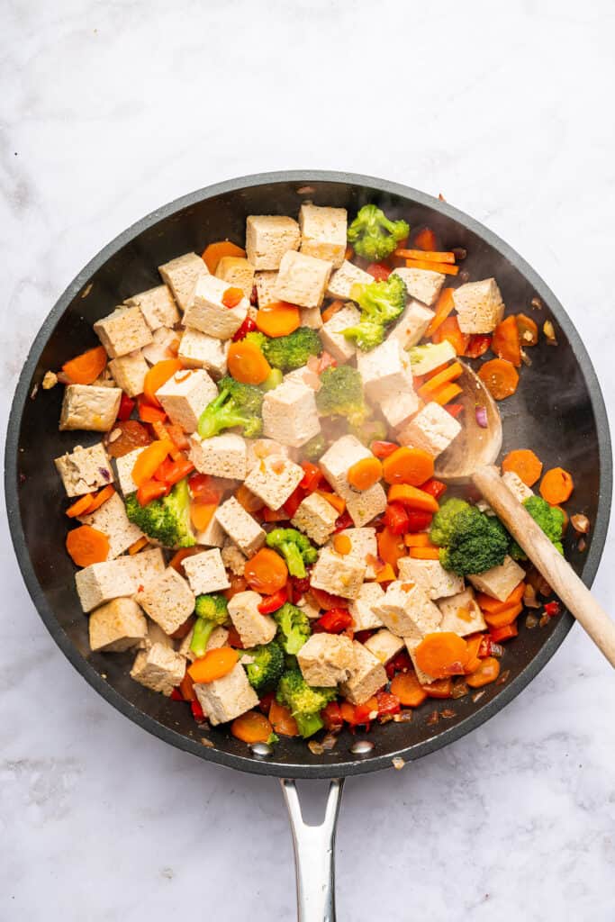 Stirring tofu and vegetables in skillet